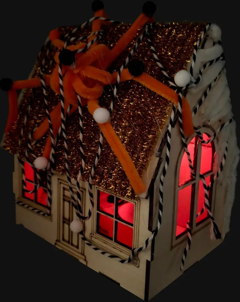 The finished haunted house glowing red from the inside in the dark